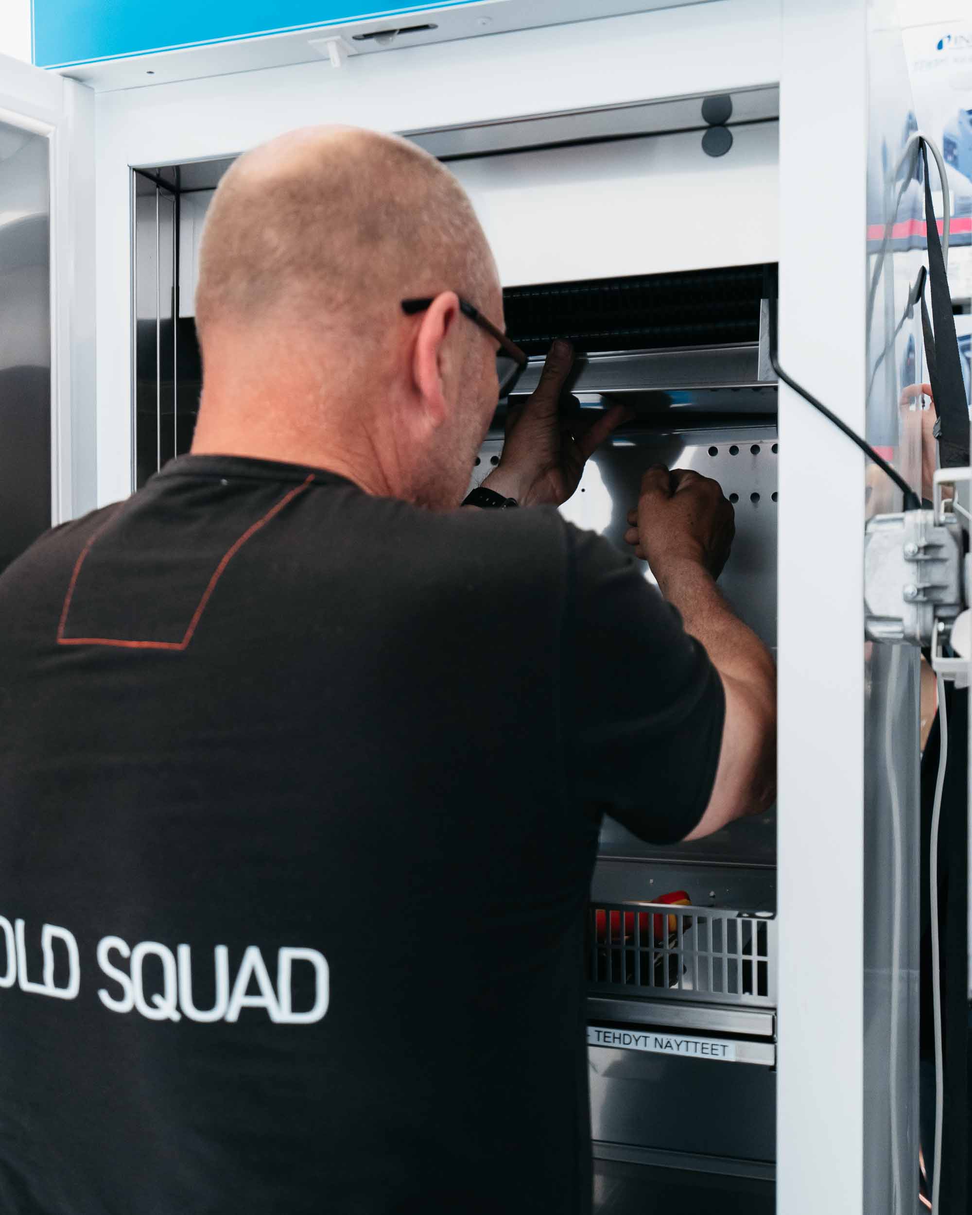 Cold Squad Oy:n teknikko huoltamassa kylmälaitetta – ammattitaitoinen kylmähuolto